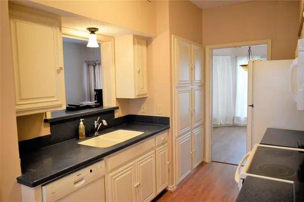 a view of empty room with wooden floor and window