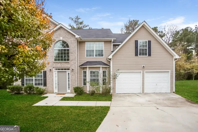 a front view of a house with a yard and garage