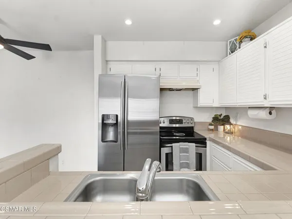 a kitchen with stainless steel appliances granite countertop a refrigerator and a sink