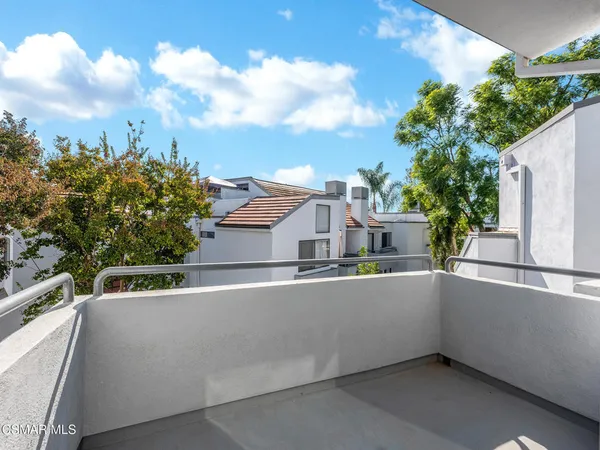 a view of a balcony with two chairs and a potted plant