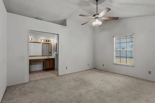 an empty room with windows and cabinet