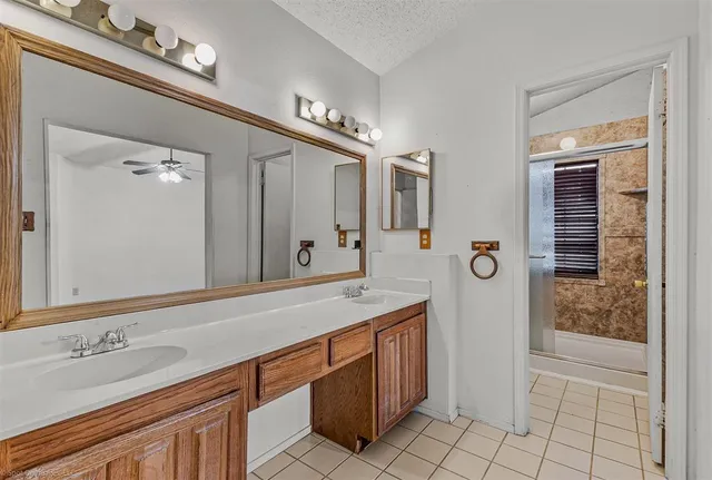 a spacious bathroom with a sink a mirror and shower