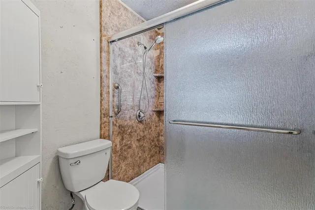 a white toilet sitting next to a shower