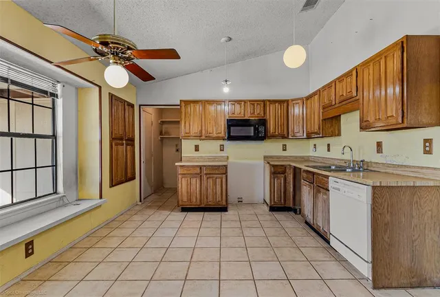 a kitchen with stainless steel appliances granite countertop a stove refrigerator sink and cabinets