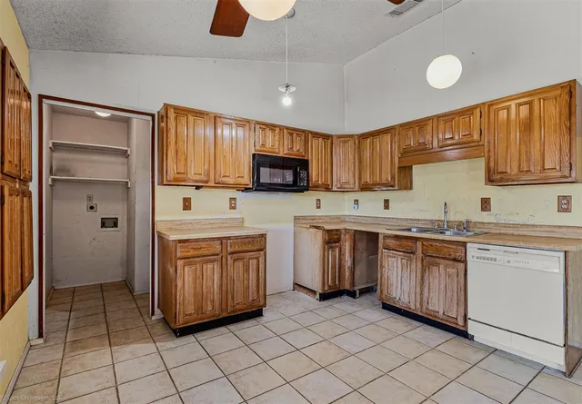 a kitchen with stainless steel appliances granite countertop a stove top oven a sink and dishwasher a refrigerator with wooden cabinets