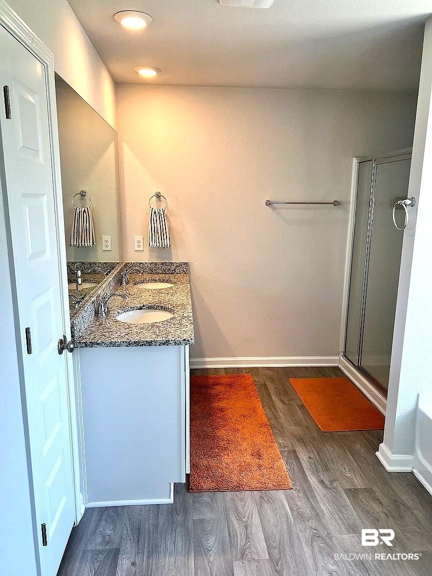 23915 Veranda Circle Elberta, AL 36530 - Photo 13 of 16 Bathroom with a stall shower, double vanity, and dark wood finished floors