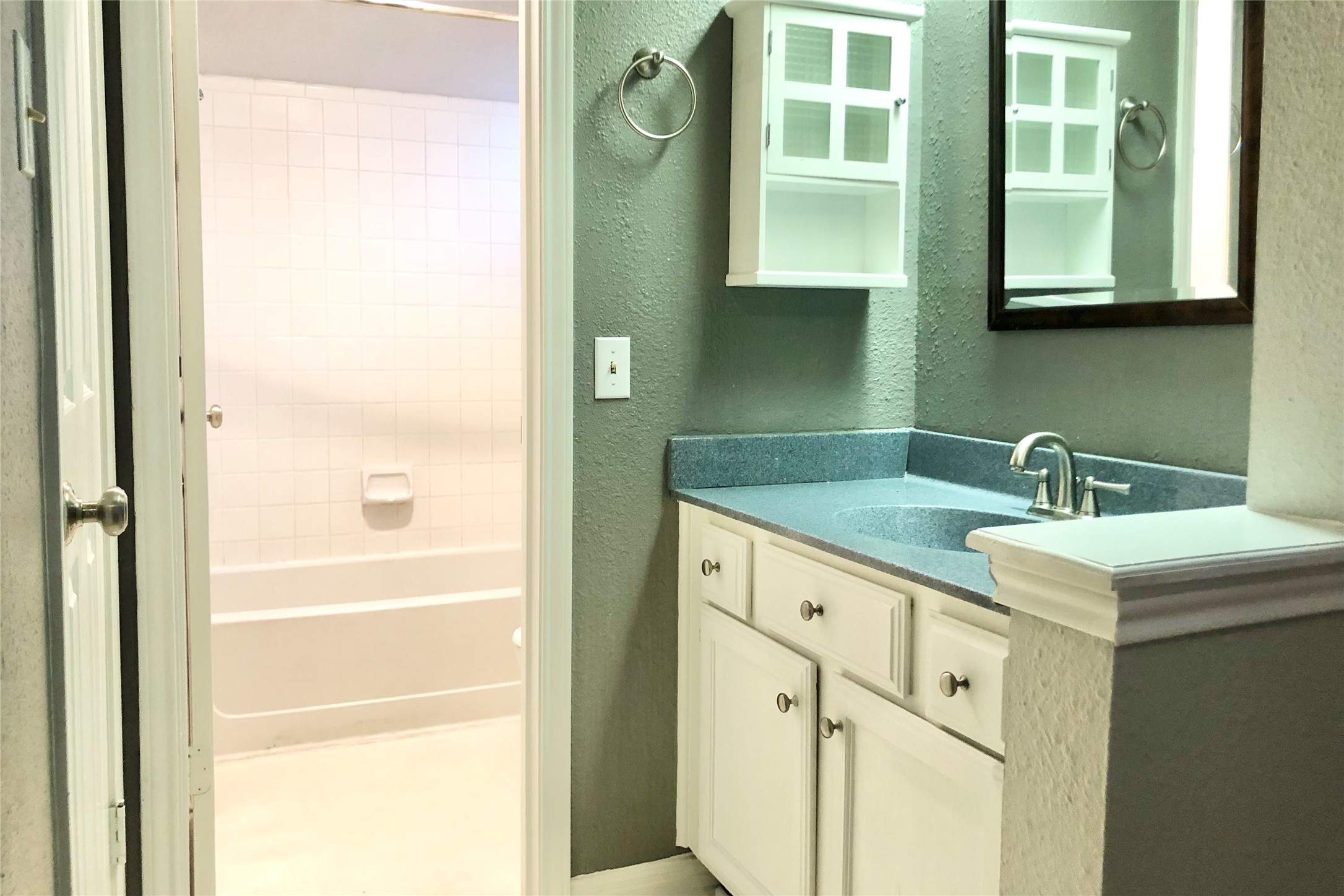 3111 Tom Green Street, Unit 204 Austin, TX 78705 - Photo 7 of 9 Bathroom featuring a textured wall, vanity, and bathing tub / shower combination