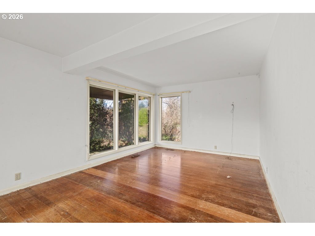 5235 Brickyard Road Tillamook, OR 97141 - Photo 4 of 14 a view of an empty room with wooden floor and a window
