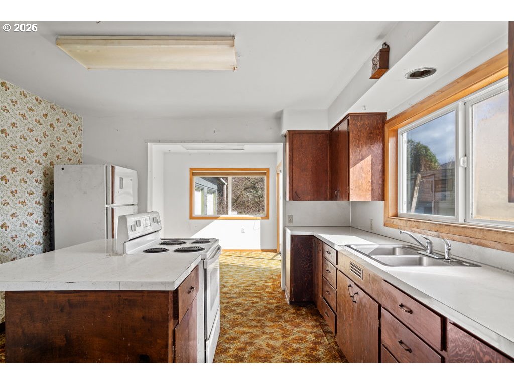 5235 Brickyard Road Tillamook, OR 97141 - Photo 6 of 14 a kitchen with stainless steel appliances granite countertop a sink stove and cabinets