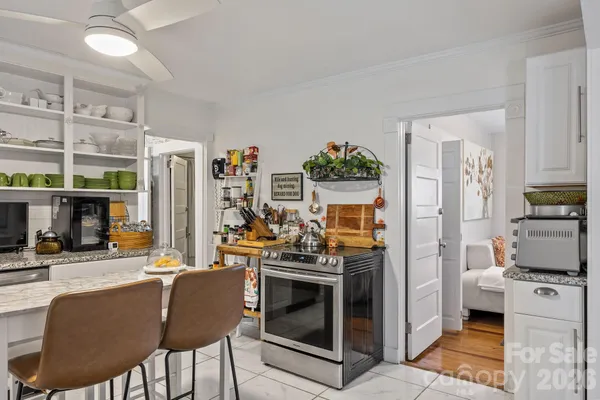 a kitchen with stainless steel appliances kitchen island granite countertop a refrigerator and a stove top oven