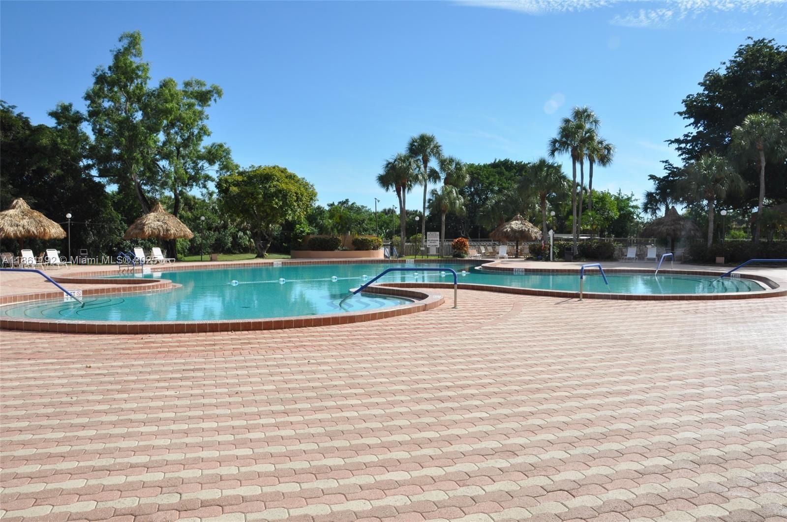 3090 Holiday Springs Boulevard, Unit 206 Margate, FL 33063 - Photo 13 of 41 a view of a swimming pool and a yard