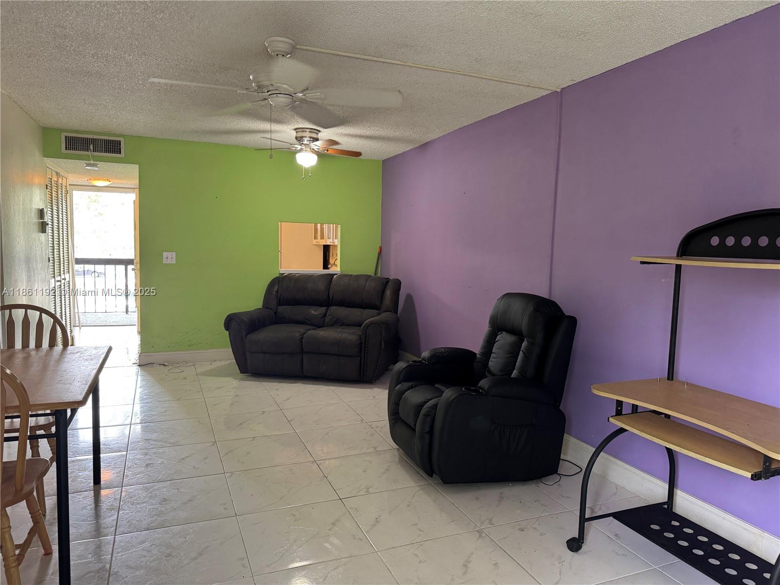 3090 Holiday Springs Boulevard, Unit 206 Margate, FL 33063 - Photo 23 of 41 a living room with furniture and a potted plant