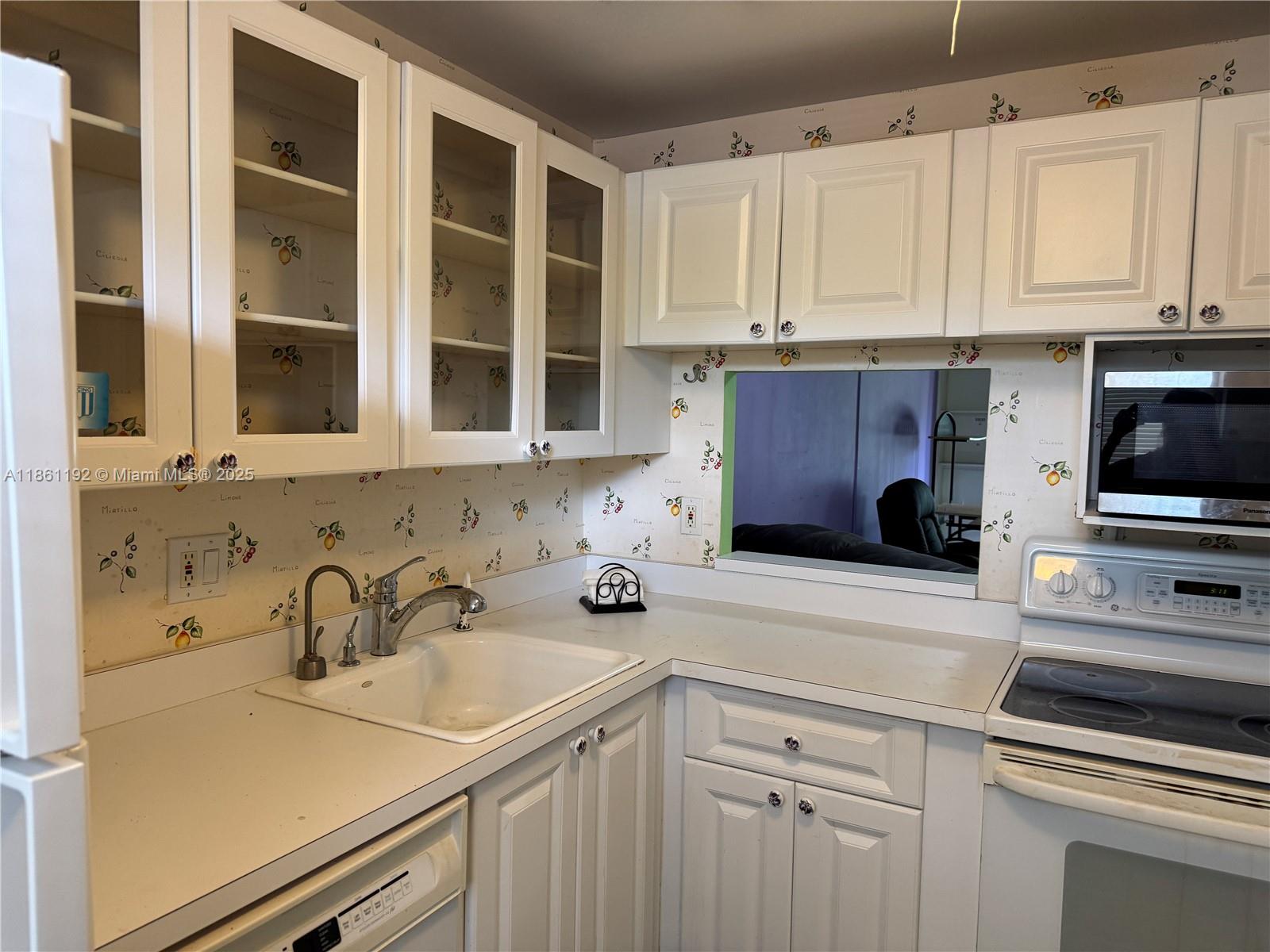 3090 Holiday Springs Boulevard, Unit 206 Margate, FL 33063 - Photo 39 of 41 a kitchen with stainless steel appliances a sink dishwasher stove and white cabinets