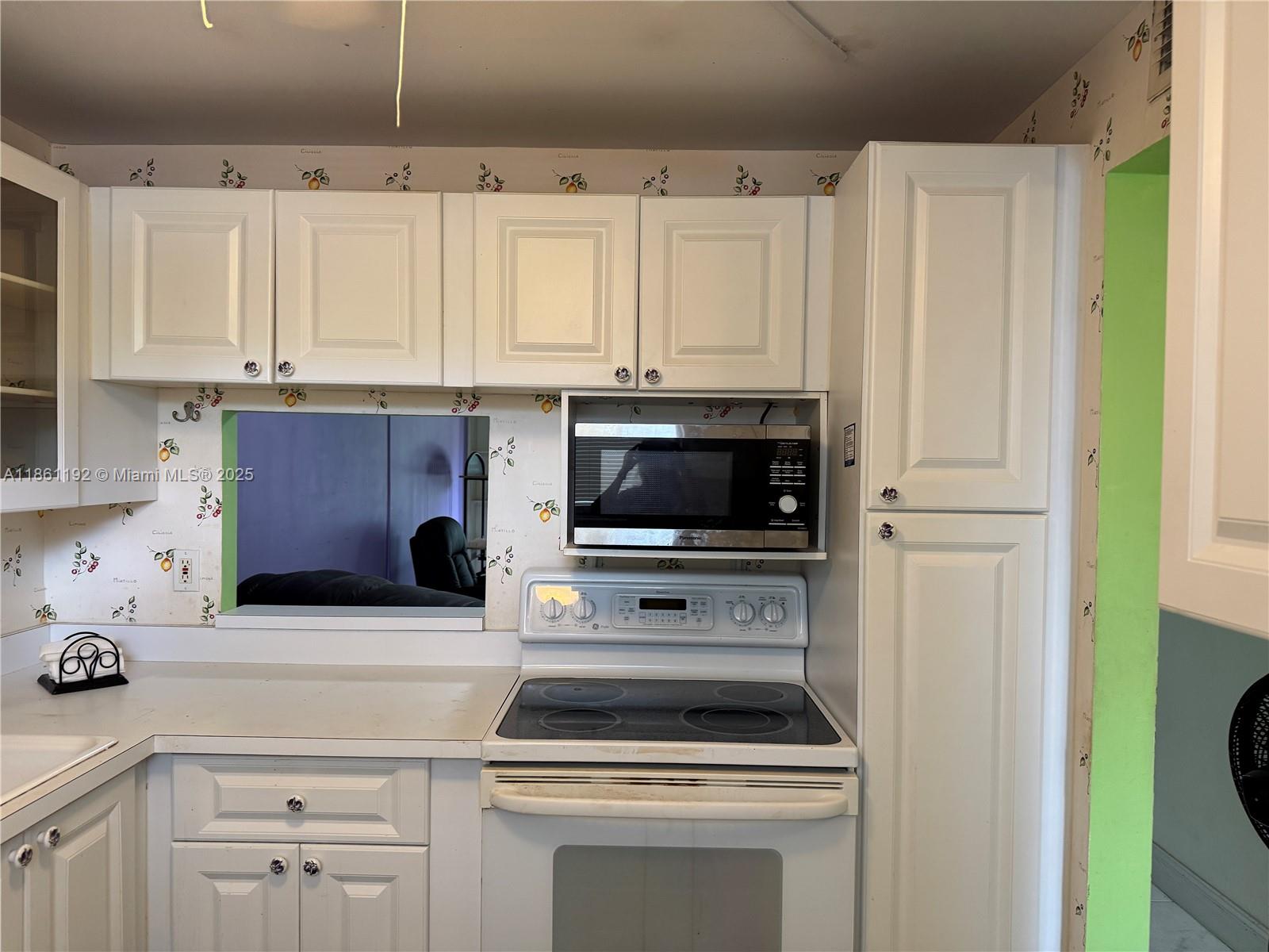 3090 Holiday Springs Boulevard, Unit 206 Margate, FL 33063 - Photo 40 of 41 a kitchen with white cabinets and appliances