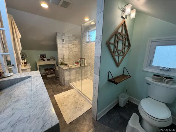 a bathroom with a toilet a sink and mirror