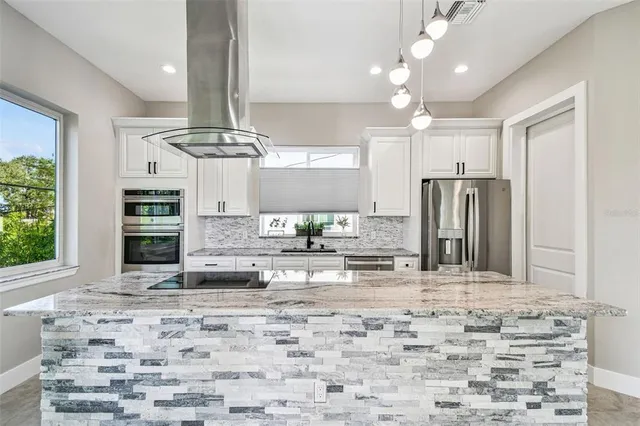 a kitchen with kitchen island granite countertop a stove cabinets and refrigerator