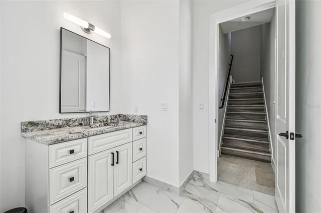 a bathroom with a granite countertop sink and mirror