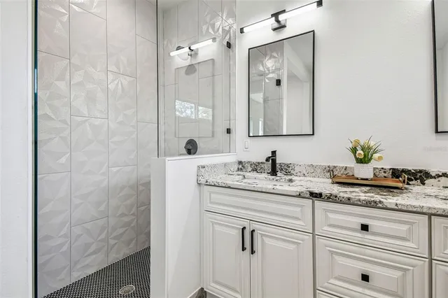 a bathroom with a granite countertop sink vanity and mirror