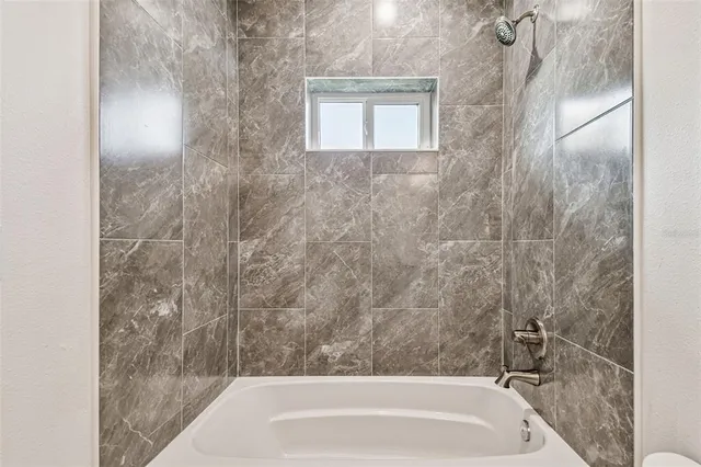 a bathroom with a bathtub and shower