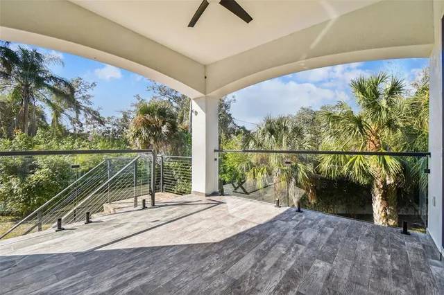 a view of a livingroom with a chandelier fan and windows