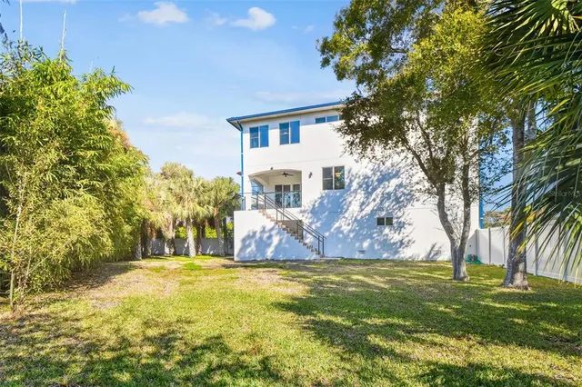 a view of a swimming pool with a big yard and large trees