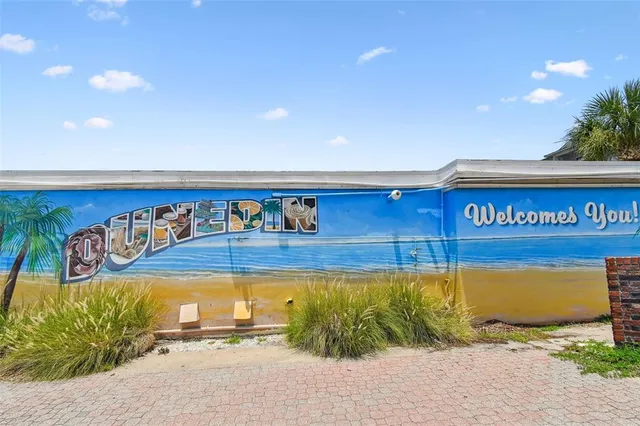 a view of a house with a yard and table and chairs under an umbrella