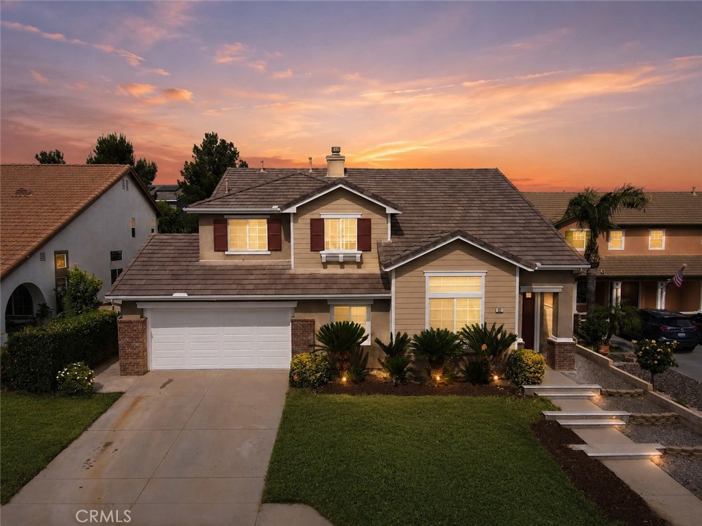 152 Alabaster Loop Perris, CA 92570 - Photo 2 of 29 a front view of a house with a garden and plants