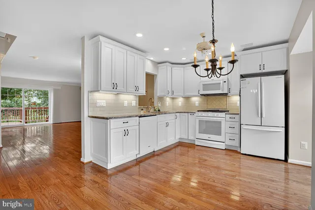 a kitchen with granite countertop white cabinets and white appliances