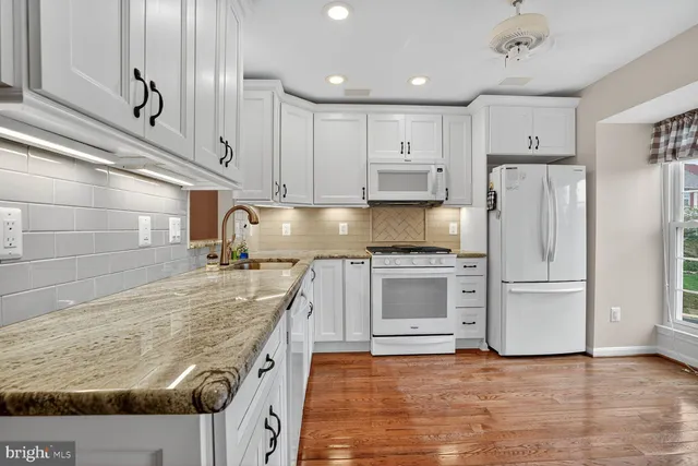 a kitchen with stainless steel appliances granite countertop a stove a refrigerator and a sink