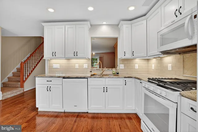 a kitchen with granite countertop a sink stove and cabinets