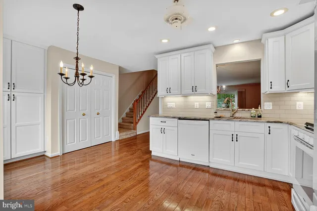 a kitchen with kitchen island granite countertop stove top oven and cabinets