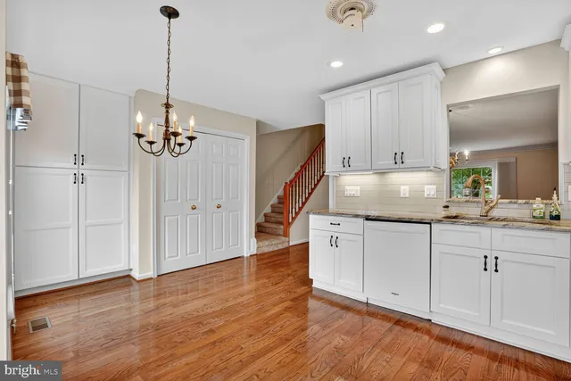 a kitchen with granite countertop white cabinets and white appliances