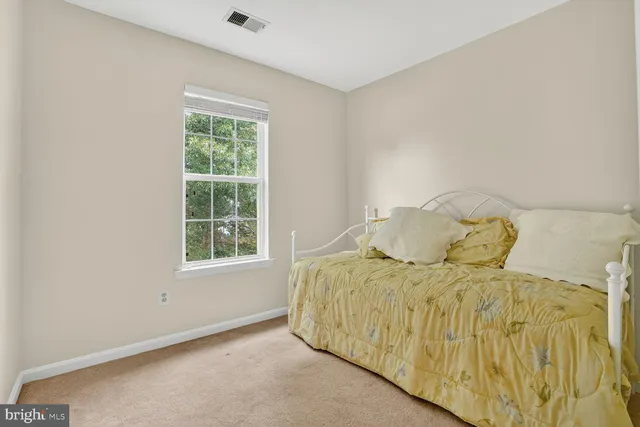 a bed sitting in a bedroom next to a window