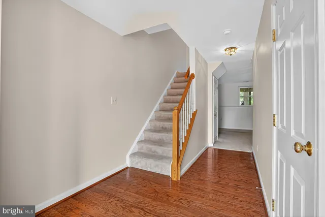 a view of a hallway with wooden floor and entryway
