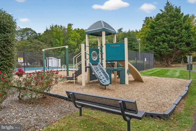a park view with a wooden fence and a slide