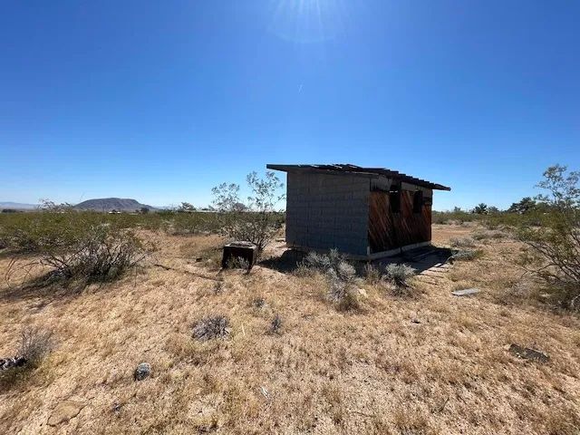 a view of a dry yard with wooden fence
