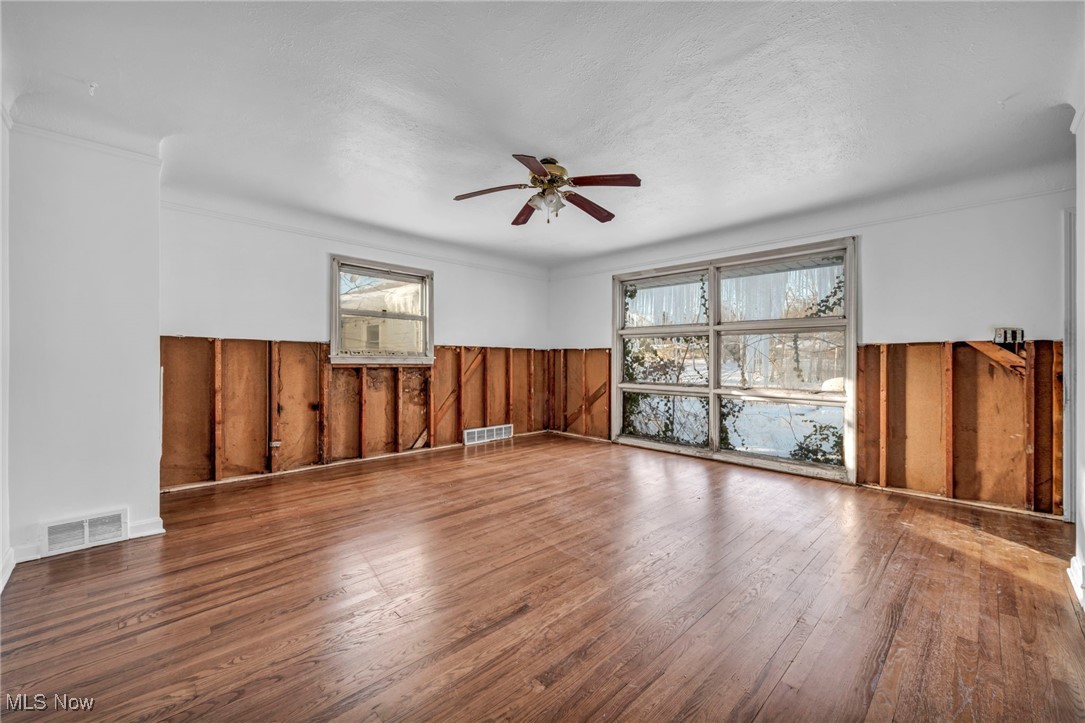14750 Schreiber Road Maple Heights, OH 44137 - Photo 30 of 44 Empty room featuring wainscoting, wooden walls, wood-type flooring, and ceiling fan