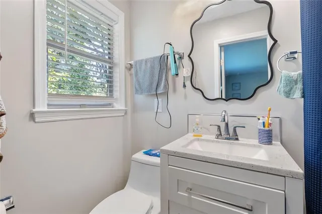 a bathroom with a toilet sink and mirror