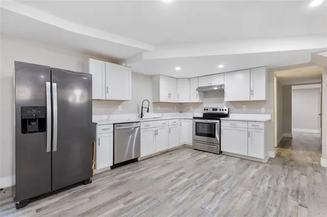 a kitchen with a refrigerator and white cabinets