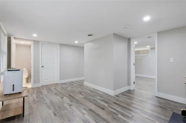 a view of an empty room with wooden floor and closet