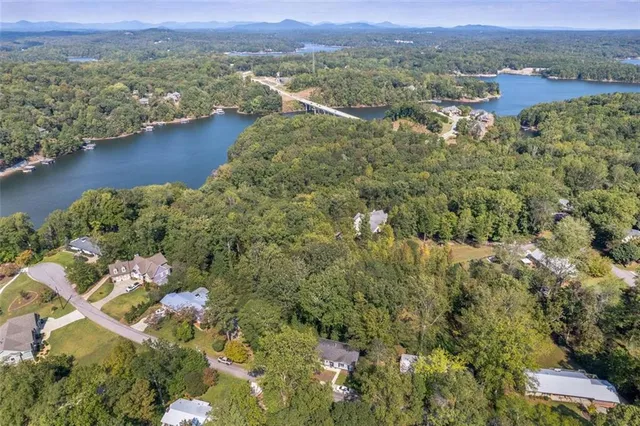 an aerial view of residential houses with outdoor space and trees