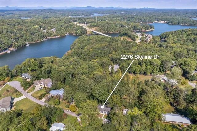 an aerial view of residential houses with outdoor space and trees
