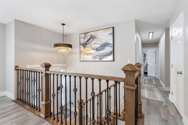 a view of hallway with furniture and a chandelier