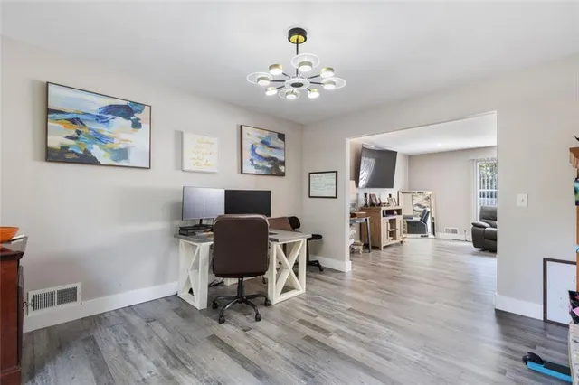 a workspace with wooden floor and a chandelier