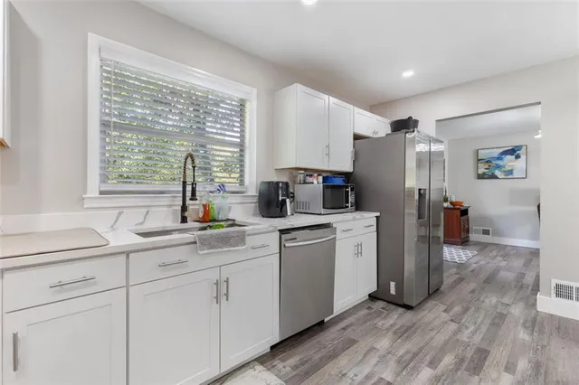 a kitchen with white cabinets and white appliances