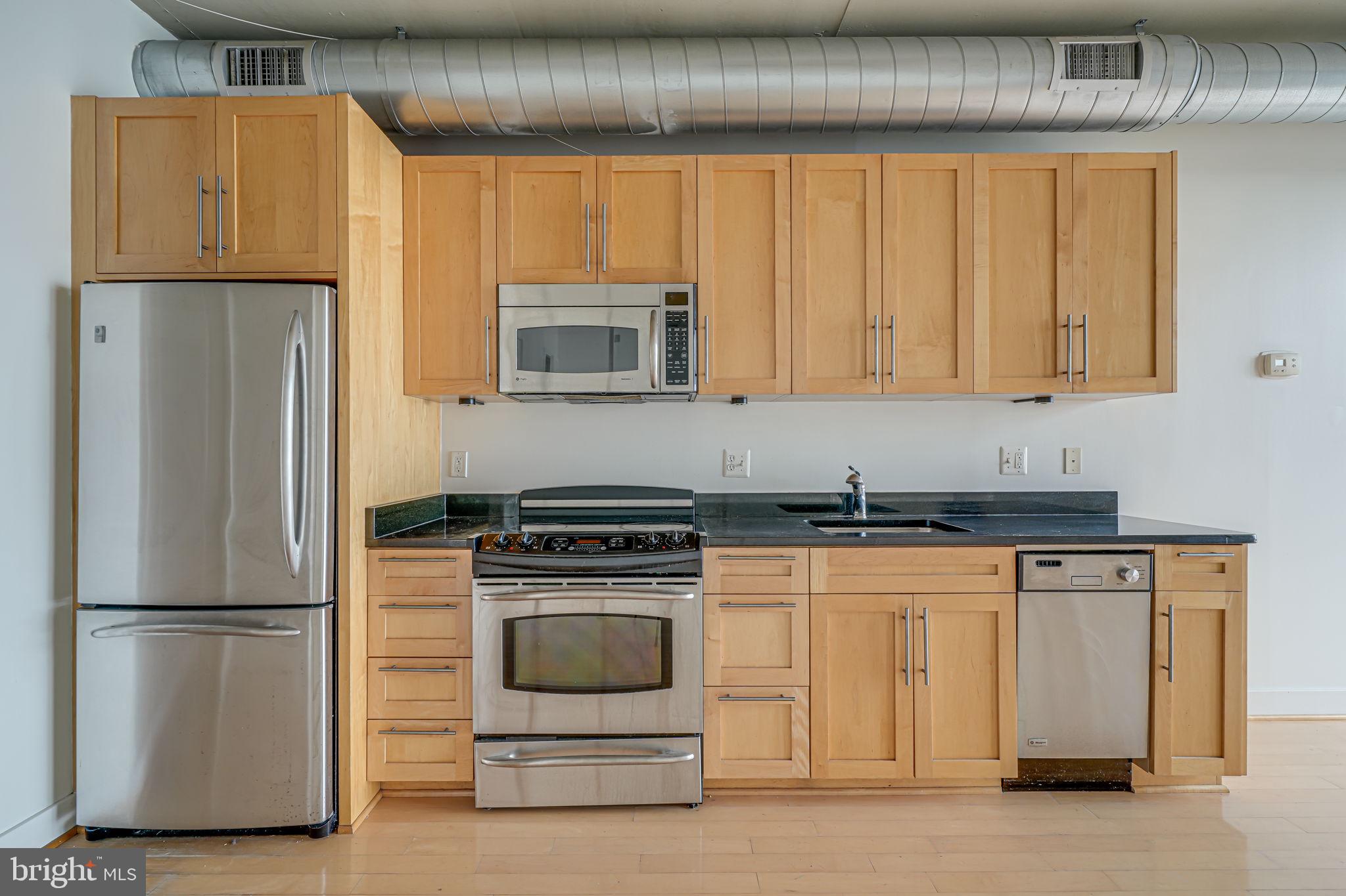 2125 14th Street Northwest, Unit 619 Washington, DC 20009 - Photo 5 of 22 a kitchen with stainless steel appliances granite countertop a refrigerator and a stove top oven