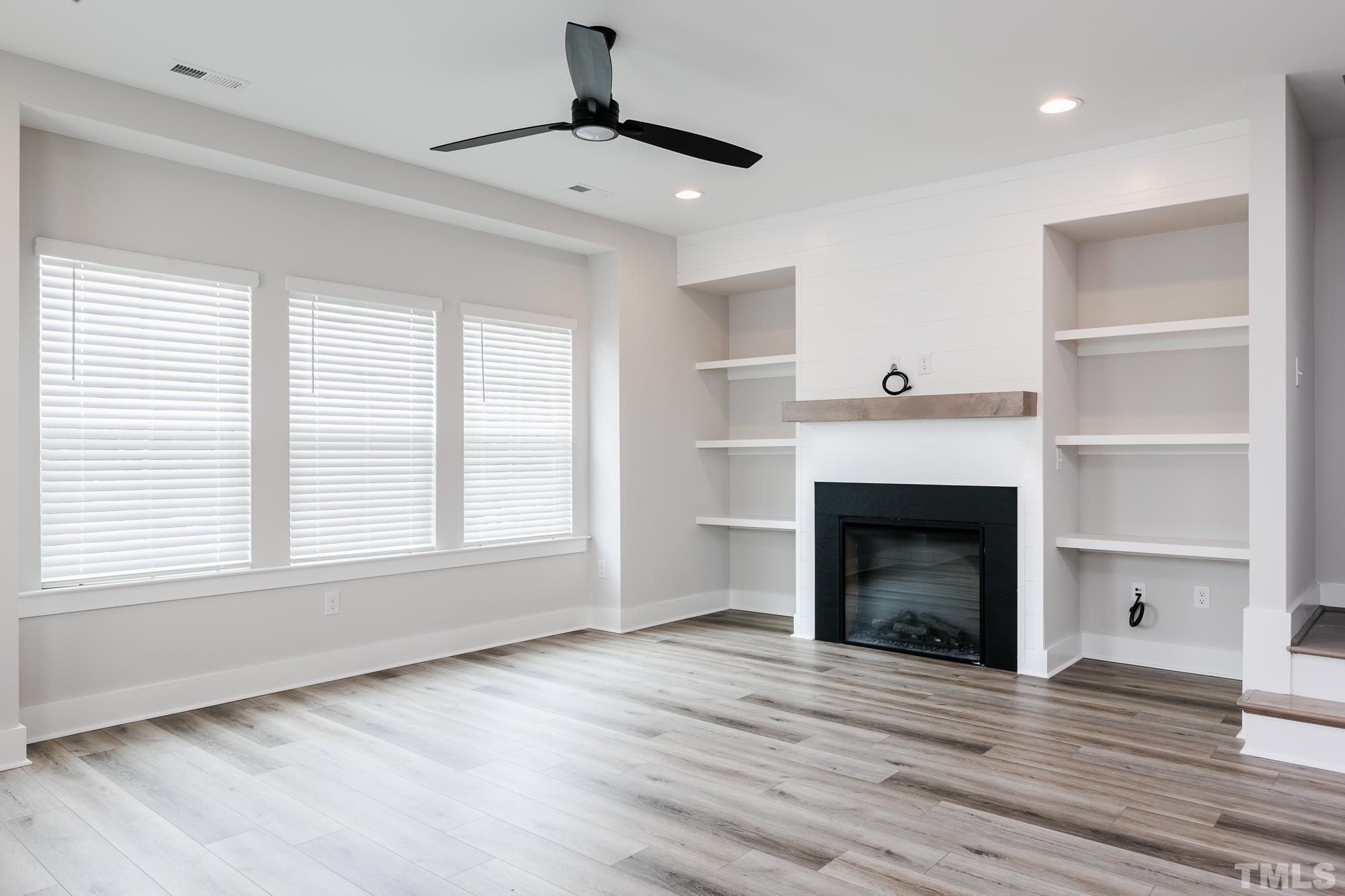 8105 Diversy Way Raleigh, NC 27613 - Photo 3 of 9 a view of empty room with a fireplace and wooden floor