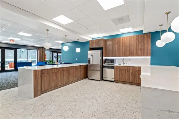 a large kitchen with a large counter top and stainless steel appliances