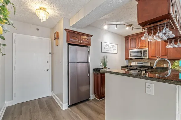 a kitchen with stainless steel appliances granite countertop a refrigerator and a sink