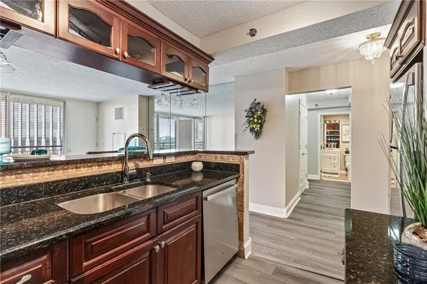 a kitchen with stainless steel appliances granite countertop a sink and a wooden floor